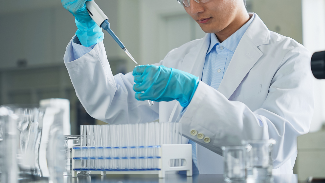 A man in a white coat experimenting in a laboratory. Image Credit: Adobe Stock Images/metamorworks