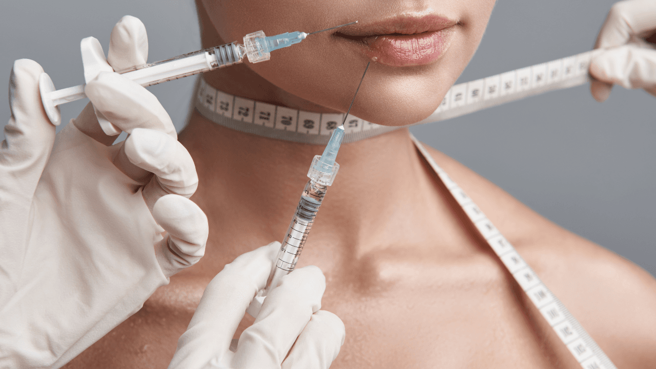 Two syringes. Doctor in white gloves making injections into the lips of young lady. Image Credit: Adobe Stock Images/Yakobchuk Olena