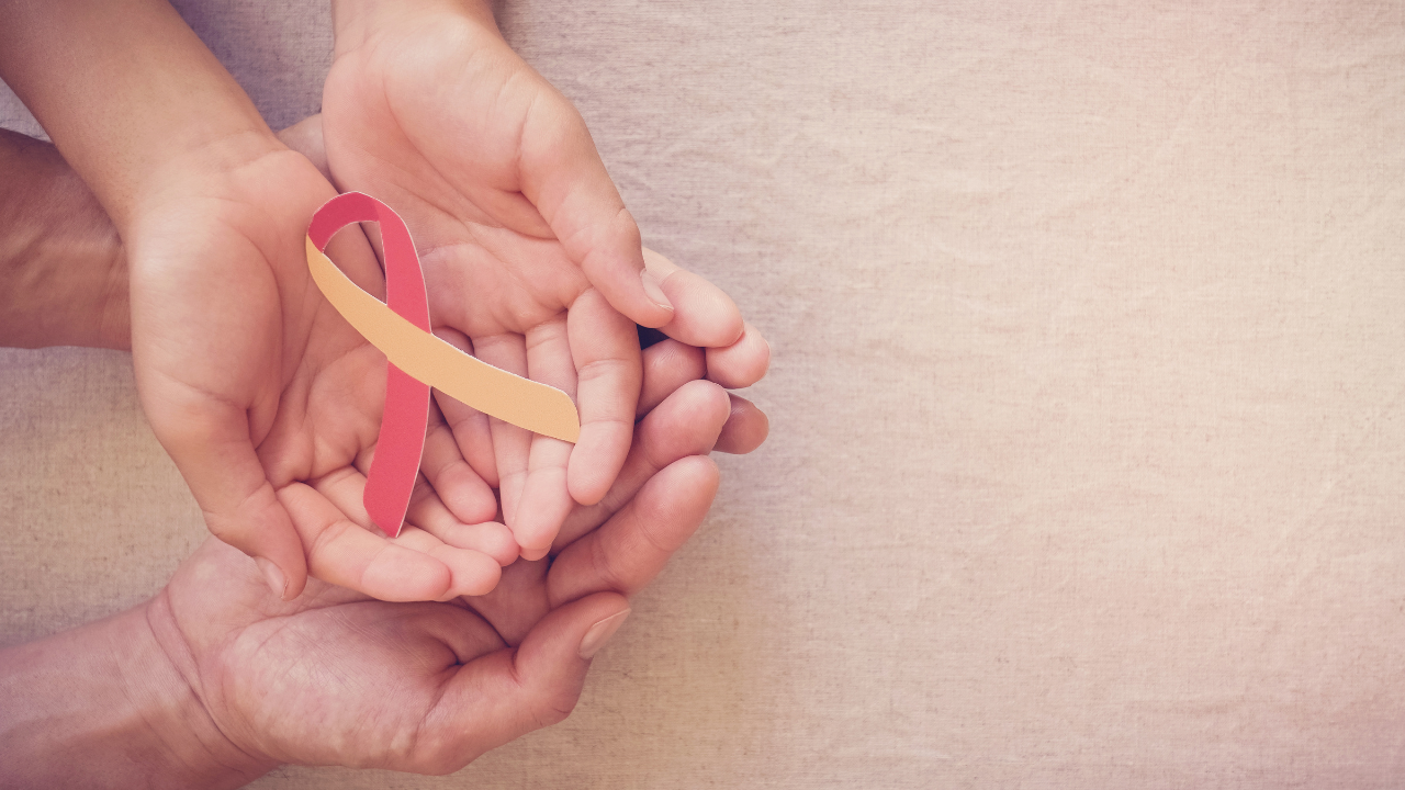 Adult and child holding red and yellow ribbon, World hepatitis day concept. Image Credit: Adobe Stock Images/SewcreamStudio